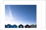 Beach huts in a row against blue skies by Assaf Frank